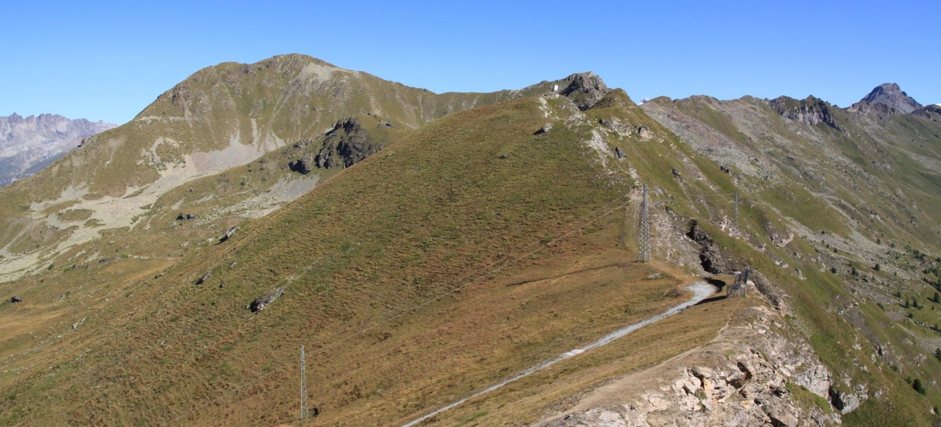 Il sentiero in cresta, con i pannelli riflettenti e il Tantanè sullo sfondo a sinistra.
