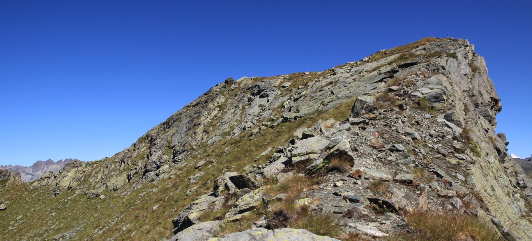 Le rocce che uniscono la cresta est del Tantanè alla costiera di confine vengono aggirate con un traverso a sinistra.