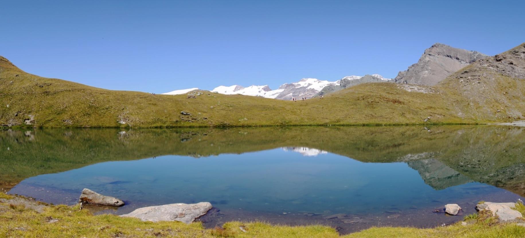Il Lago Perrin dalla sponda sud, con il panorama sul Rosa e sul Testa Grigia.